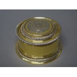 A silver gilt box and cover, of circular form, decorated with gadrooned rims,