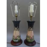 A pair of modern Moorcroft table lamps, decorated in the `Cluny' pattern,