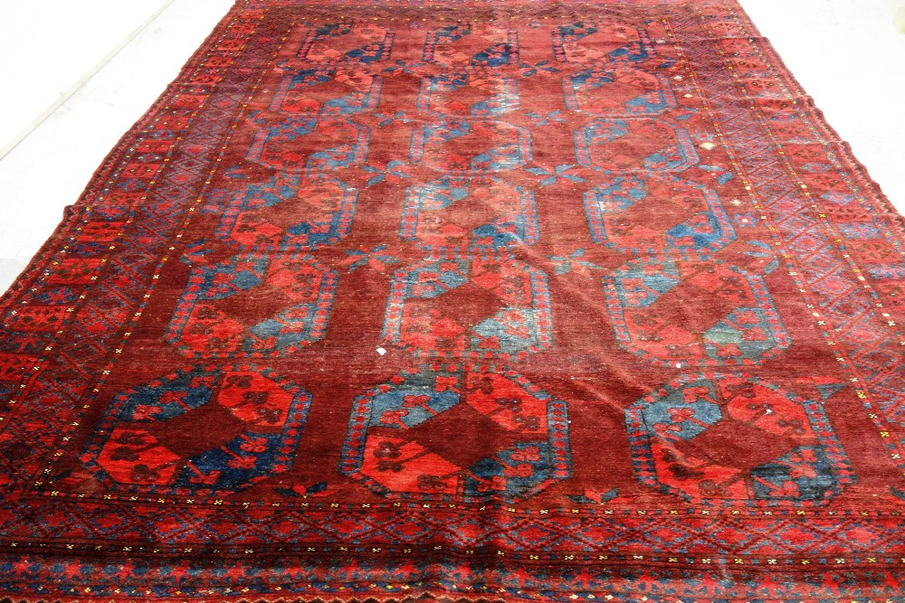 An Afghan Esari carpet, the dark madder field with three columns of six bold guls, - Image 7 of 12