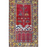 An antique Ladik prayer rug, the madder mihrab with a delicate flowering plant,
