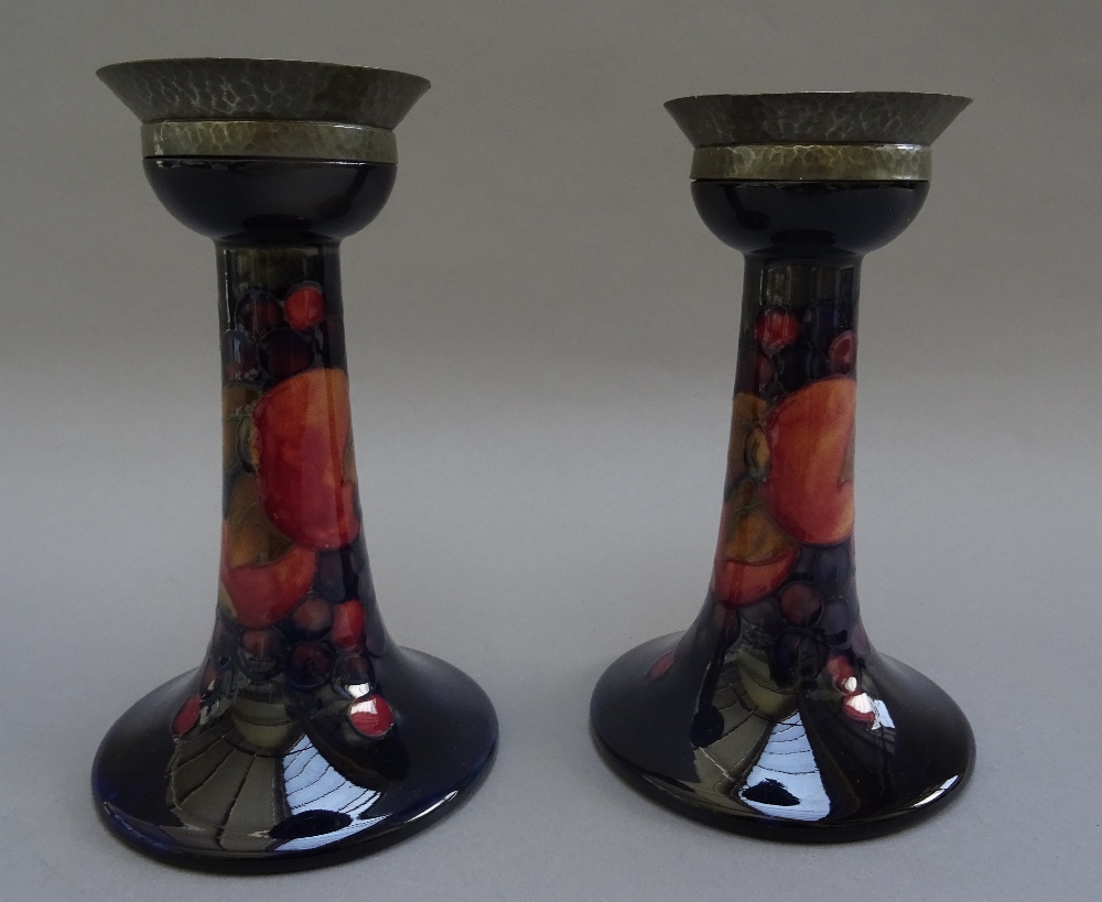 A pair of Moorcroft pottery candlesticks, decorated in the 'Pomegranate' pattern, circa 1920,