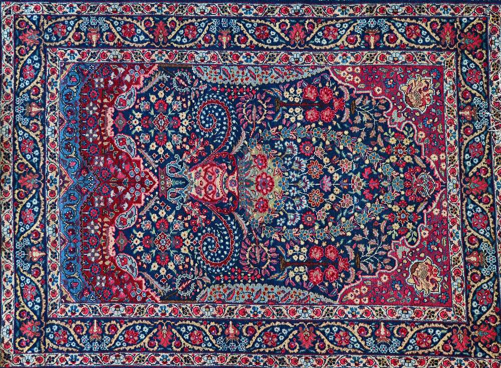 A pair of Tabriz prayer rugs, Persian, the dark indigo floral mihrab with a large vase,