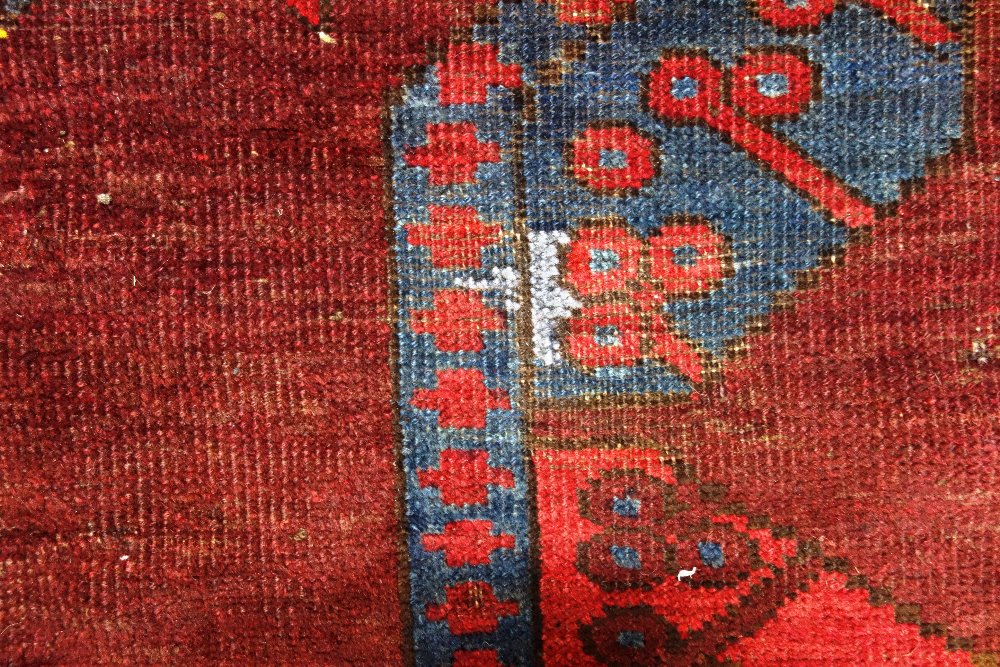 An Afghan Esari carpet, the dark madder field with three columns of six bold guls, - Image 3 of 12