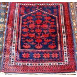 A Belouche prayer rug, the indigo mehrab with a madder flowering tree, madder stars beneath.