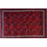 An Afghan Kizil Ayak carpet, the plain madder filed with three columns of six guls,