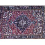 An Heriz carpet, Persian, the madder field with a black diamond, white spandrels,