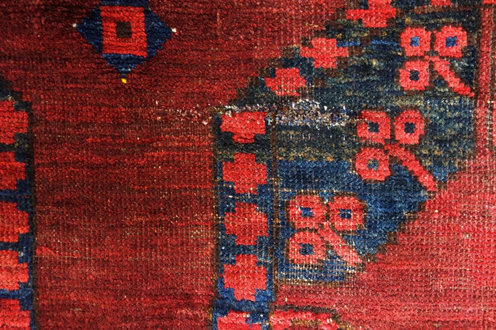 An Afghan Esari carpet, the dark madder field with three columns of six bold guls, - Image 5 of 12