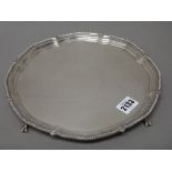 A silver salver, of shaped circular form, decorated with a beaded rim,