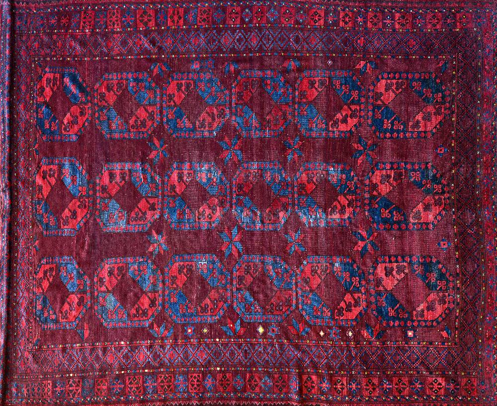 An Afghan Esari carpet, the dark madder field with three columns of six bold guls,