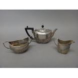 A late Victorian silver composite three piece tea set, comprising; a teapot,