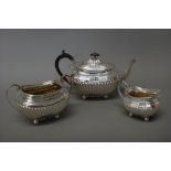 A silver three piece tea set, comprising; a teapot, a twin handled sugar bowl and a milk jug,