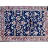 A Tabriz carpet, Persian, the dark indigo field with allover design, with bold ivory palmettes,