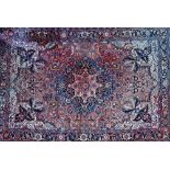 A Heriz carpet, Persian, the madder field with a bold shaped medallion, ivory spandrels,