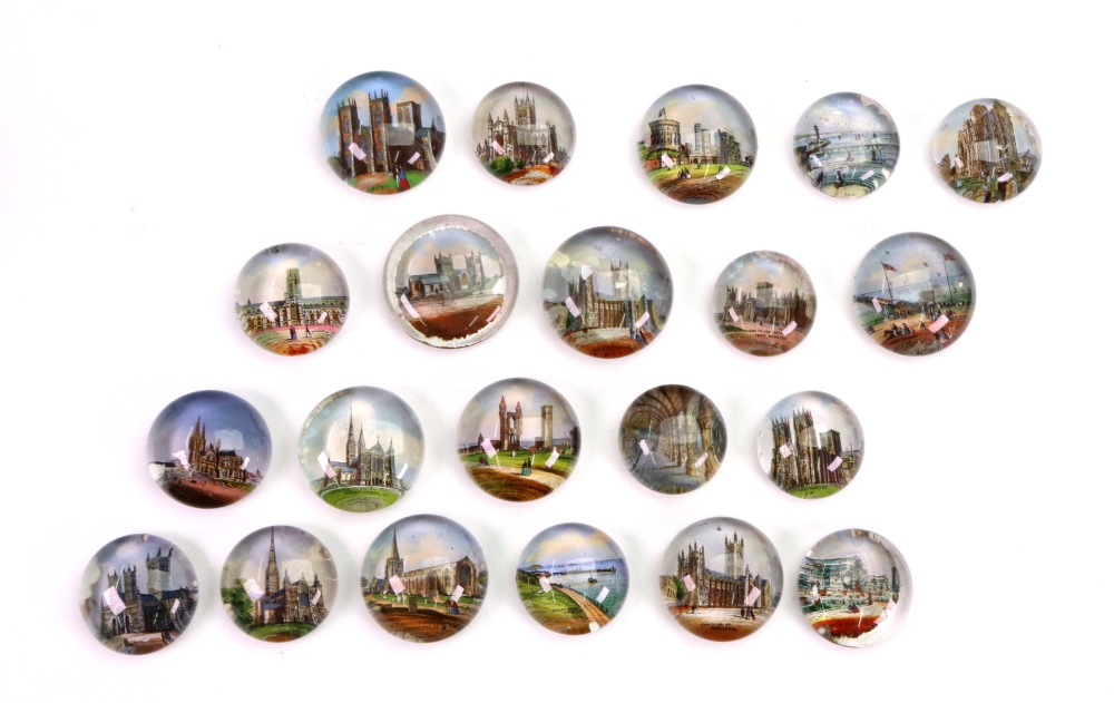 A collection of twenty one old circular glass paperweights mostly of British cathedrals and