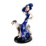 A Goldscheider pottery figure of a fashionable young lady standing beside a borzoi dog, circa 1930,