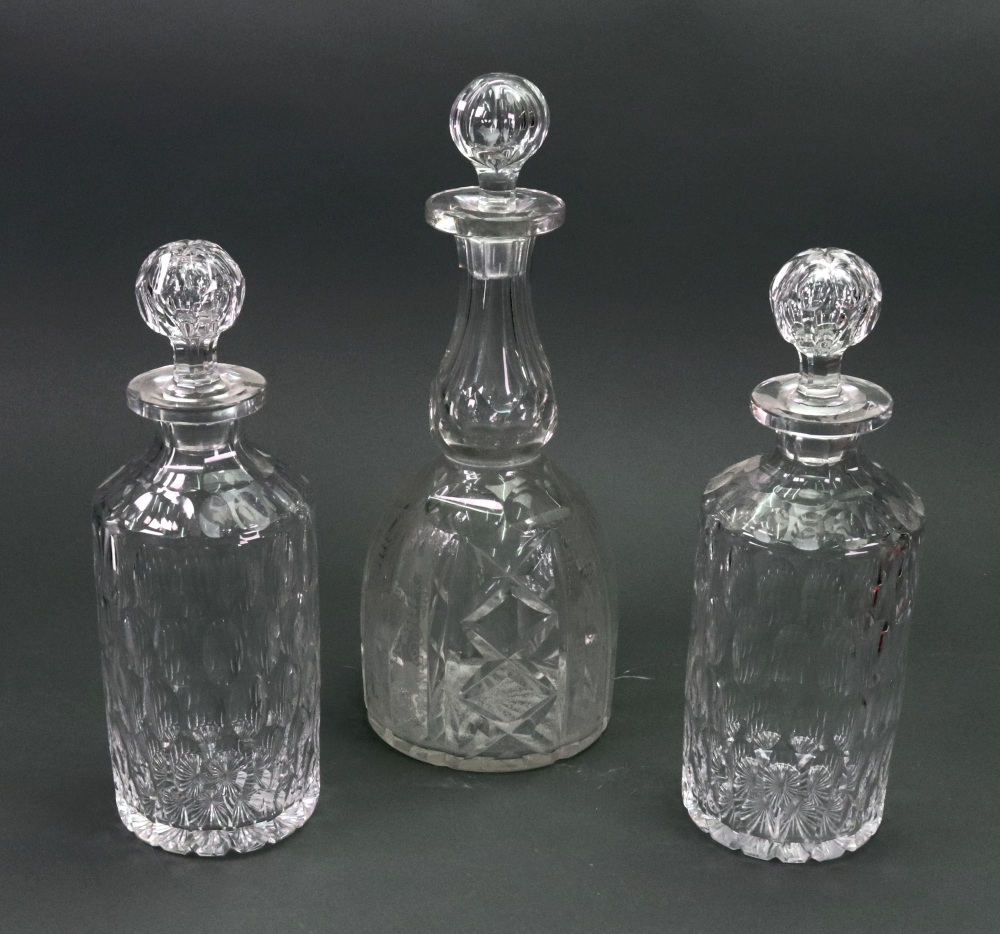 A pair of cylindrical glass decanters, late 19th/early 20th century, cut with bands of oval facets,