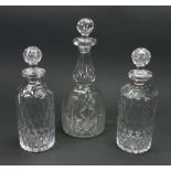 A pair of cylindrical glass decanters, late 19th/early 20th century, cut with bands of oval facets,