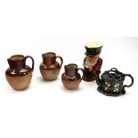 A graduated set of three Doulton Lambeth stoneware harvest jugs,