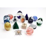 A collection of eleven contemporary multi coloured glass paperweights, of varying shapes and sizes,