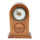 An Arts & Crafts style Oak mantel timepiece in the manner of Archibold Knox,