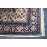 An Indian carpet, modern of West Persian design, the ivory field with an all over herati design,