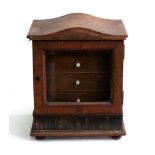 A Victorian walnut domed table top jewel chest, fitted with four drawers enclosed by a glazed door,