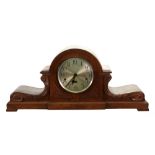 An early 20th century German arched foliate carved oak case mantel clock, with silvered dial,