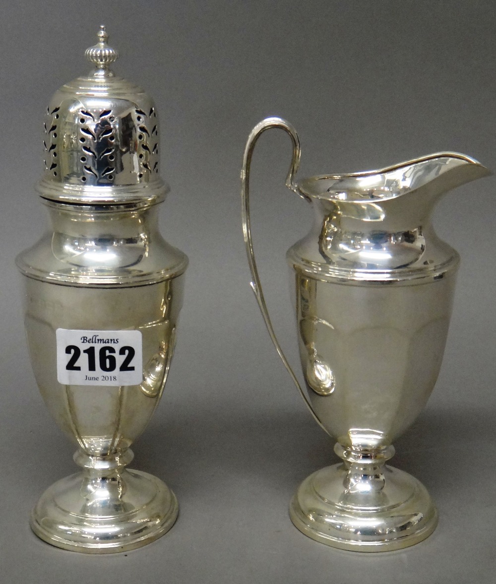 A silver sugar caster and a milk jug in a similar design,