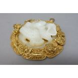 A Chinese white jade circular plaque, carved with two birds amongst lotus,