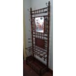 A Victorian faux bamboo turned hall stand, with mirrored back over twelve division stick stand,