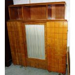 A mid 20th century oak side cupboard with glazed door flanked by geometric carved panel doors,