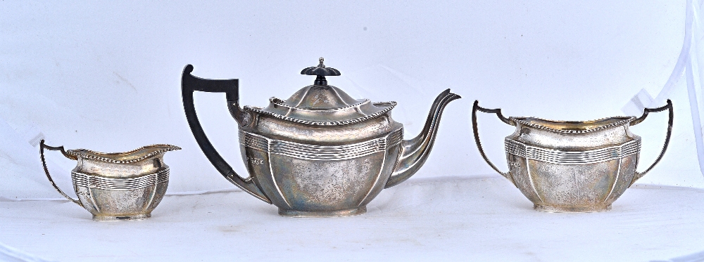 A silver three piece tea set, comprising; a teapot, a twin handled sugar bowl and a milk jug,