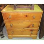 An early 20th century pine chest of three long drawers, on bracket feet with bun handles,