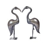 A pair of large Middle Eastern damascened metal storks, each bird standing looking straight ahead,