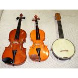 Musical instruments, comprising; two 20th century violins, cased and a banjolele (3).