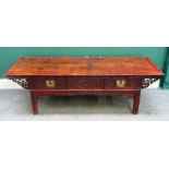 A 20th century Eastern red lacquered hardwood low table, the carved frieze with three drawers,