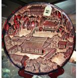 A Chinese circular lacquered wood landscape panel, 25cm. diameter.