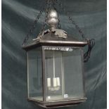 A modern silvered metal hall lantern of square form with an acorn finial,