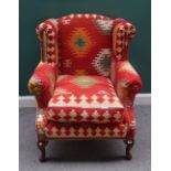 A pair of mid-18th century style wingback armchairs, in Tabriz carpet upholstery,