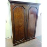 A George III mahogany knock-down wardrobe, with pair of arched panel doors on bracket feet,