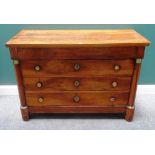 An early 19th century French gilt metal mounted walnut four drawer commode, with turned columns,