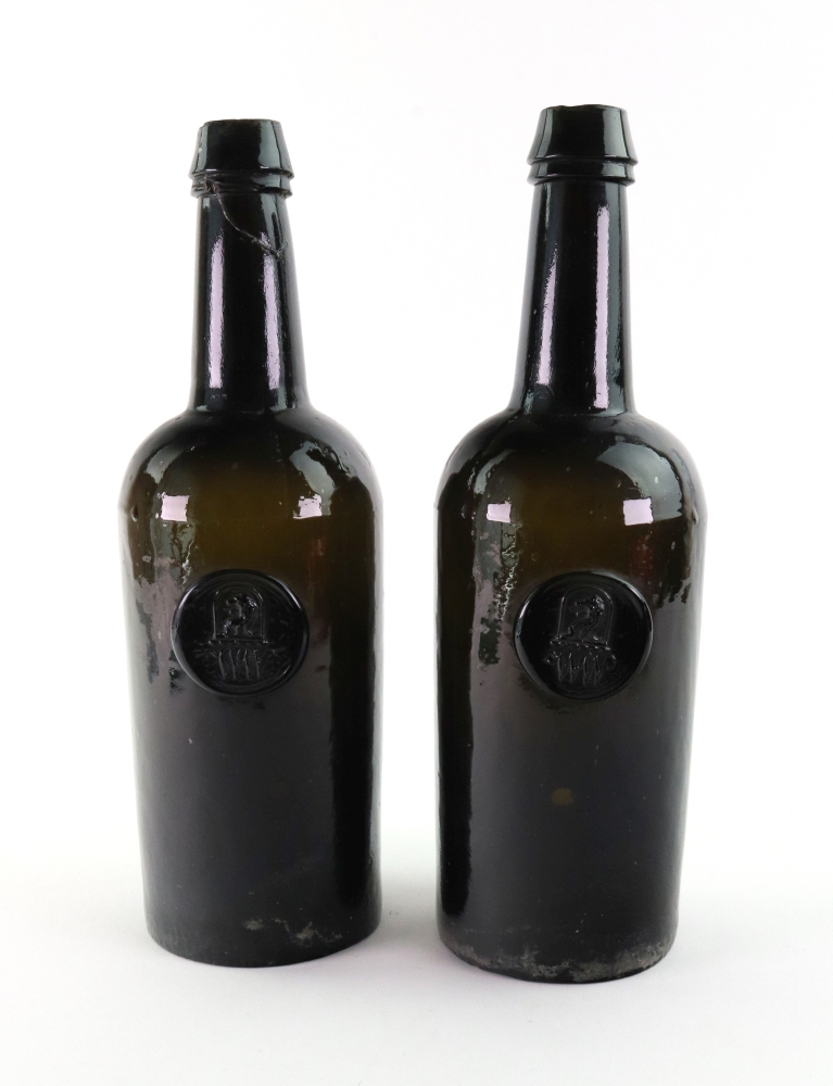 A pair of green glass wine bottles, by H