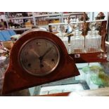 An early 20th century mahogany mantel clock, 22cm high and an oak bound tantalus with decanters,