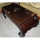 A 20th century Chinese hardwood low table with carved elephant inset panel on dual outswept