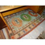 A Turkish rug, with a green and two red medallions, 206cm x 133cm.