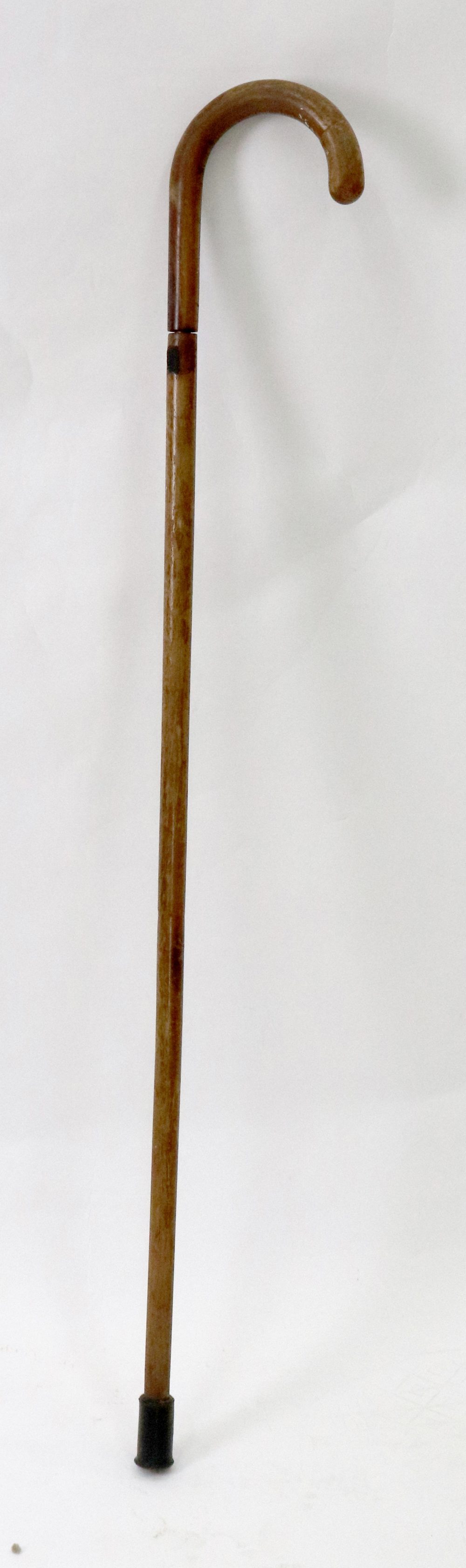 A hardwood walking stick, circa 1900, with curved handle and containing a kosh, 92cm long.