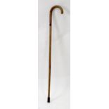 A hardwood walking stick, circa 1900, with curved handle and containing a kosh, 92cm long.