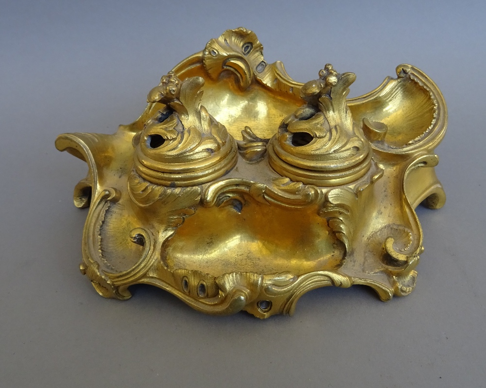 A French rococo style ormolu encrier, 19th century, with twin inkwells and pierced hinged lids, 18.
