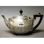 A Victorian silver teapot, of oval form, with partly fluted decoration and with ebonised fittings,
