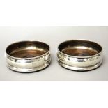 A pair of silver mounted circular bottle coasters,